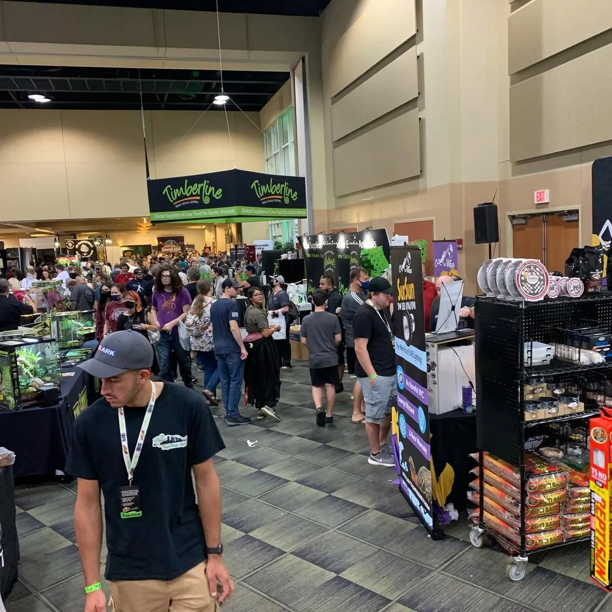 Shoppers moving down an aisle between vendor booths